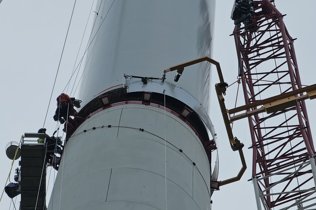 Montagearbeiten am Turm einer Windenergieanlage mit Kran